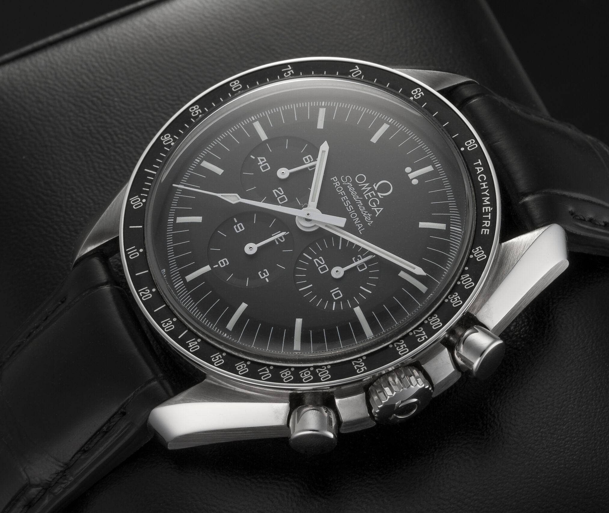 Milan, Italy - August 25, 2024: close up on Omega Speedmaster Moonwatch luxury wrist watch with alligator strap on a leather stand. No people are visible.